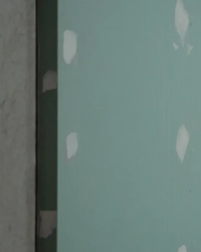 Plaque de plâtre hydrofuge à parement vert, têtes de vis rebouchées